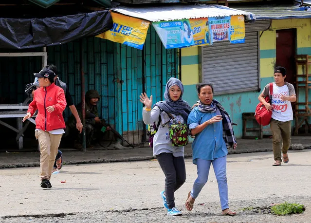 Residents run to evacuate during government troops assault with insurgents from the so-called Maute militants, who have taken over large parts of the Marawi city, southern Philippines May 25, 2017. (Photo by Romeo Ranoco/Reuters)