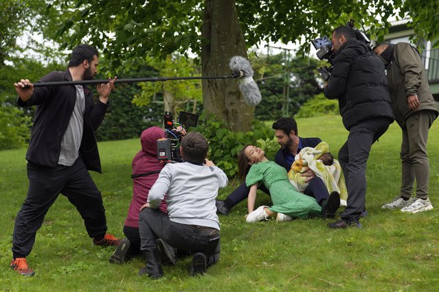 A production team films a scene from a Turkish television drama with actors Paris Baktas and Yagmur Yuksel, in Istanbul, April 30, 2024. (Photo by Khalil Hamra/AP Photo)