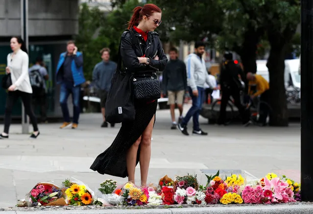 A woman looks at flowers left at the south end of London Bridge, near Borough market following an attack which left 7 people dead and dozens of injured in central London, Britain, June 5, 2017. (Photo by Peter Nicholls/Reuters)