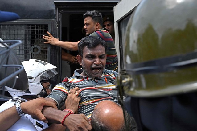 An activist of the Bharatiya Janata Party (BJP) shouts slogans after being detained by police during a protest rally, in Kolkata on August 28, 2024. Numerous protests in Kolkata prompted by the rape and murder of a doctor have transformed into unruly political rallies, with police scuffling with demonstrators from the ruling BJP angry at the state government. (Photo by Dibyangshu Sarkar/AFP Photo)