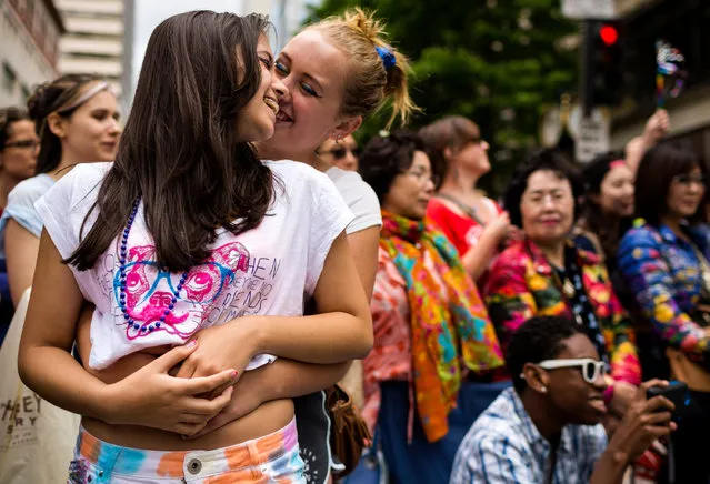 Two young women hold each other and kiss while watching the 40th annual Seattle Pride Parade Sunday, June 29, 2014, in Seattle, Wash. This year's theme was “Generations of Pride”. (Photo by Jordan Stead/AP Photo/Seattlepi.com)