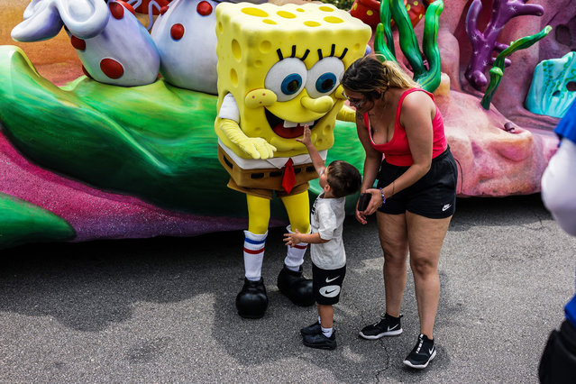 A boy meets a mascot of SpongeBob during the “Superstar Parade” at Universal Studios Florida in Orlando, Florida on May 19, 2022. “Universal’s Superstar Parade will end its run on June 4 to make way for new entertainment experiences”, Universal Orlando said in a statement. (Photo by Chandan Khanna/AFP Photo)
