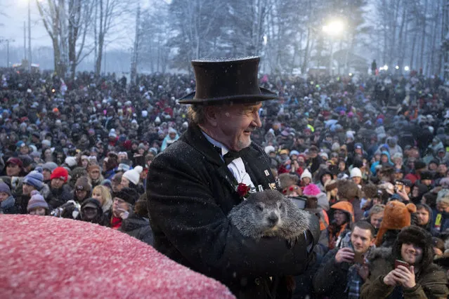Groundhog Club co-handler John Griffiths holds Punxsutawney Phil, the weather prognosticating groundhog, during the 134th celebration of Groundhog Day on Gobbler's Knob in Punxsutawney, Pa. Sunday, February 2, 2020. Phil's handlers said that the groundhog has forecast an early spring. (Photo by Barry Reeger/AP Photo)