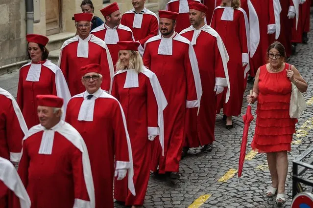 Members of the “Jurade of Saint-Emilion”, wearing red caps and robes decorated with white ermine, walk through the streets of Saint-Emilion, before an induction ceremony of the brotherhood ahead of Bordeaux' Wine Week on June 19, 2022. Founded 800 years ago and revived in 1948, the Jurade preserves the memory of Saint-Émilion wines and promotes them all over the world. (Photo by Thibaud Moritz/AFP Photo)