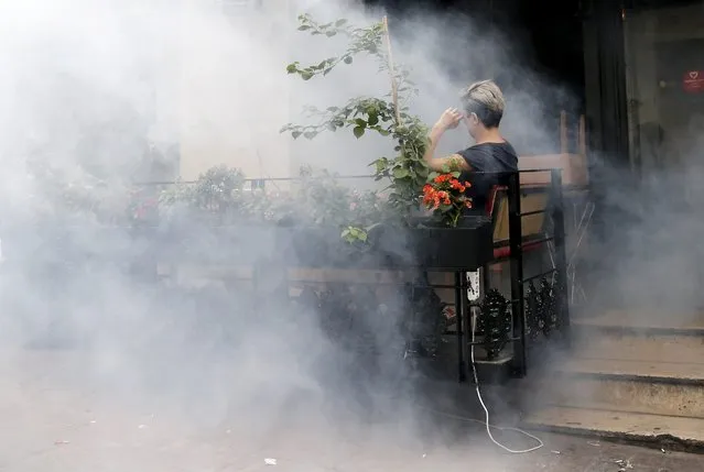 A woman sits in the midst of smoke as Turkish police use tear gas to against participants during the Istanbul LGTB Pride Parade which was cancelled due to security concerns by the governor of Istanbul, in Istanbul, Turkey, 26 June 2016. Transgenders people and supporters try to march in central Istanbul as part of the Trans Pride Week 2016, which is organized by Istanbul's “Lesbians, Gays, Bisexuals, Transvestites and Transsexuals” (LGBT) solidarity organization. (Photo by Sedat Suna/EPA)