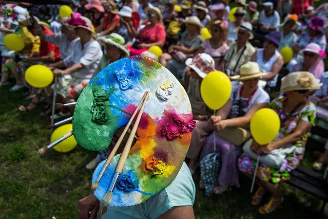 A woman wearing a fancy hat participates in the 8th “March of a Hats” through the city of Bydgoszcz, Poland, 30 June 2016. The march was held as part of the Universities of the Third Age Juvenalia under the slogan “Visible Senior – Safe Senior”. (Photo by Tytus Zmijewski/EPA)