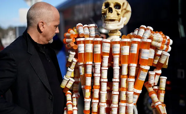 Frank Huntley looks at his sculpture made out of the opioid pill bottles he got when addicted, set up outside Democratic presidential candidate and former Vice President Joe Biden's campaign event in Somersworth, New Hampshire, U.S., February 5, 2020. (Photo by Rick Wilking/Reuters)