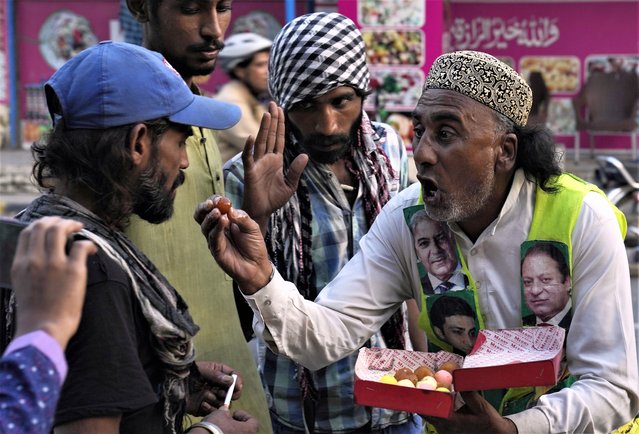 A Supporter of Pakistan Muslim League -N distributed sweets among people, in Lahore, Pakistan, Saturday, August 5, 2023. Pakistani police on Saturday arrested Khan at his home in the eastern city of Lahore after a court convicted him in an asset concealment case and handed him down a three-year prison sentence. (Photo by K.M. Chaudary/AP Photo)