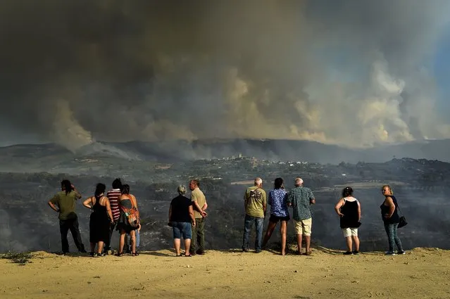 Local people watch the clouds of smoke during a forest fire in Linhares da Beira, Celorico da Beira, northern Portugal, 11 August 2022. (Photo by Nuno Andre Ferreira/EPA/EFE)