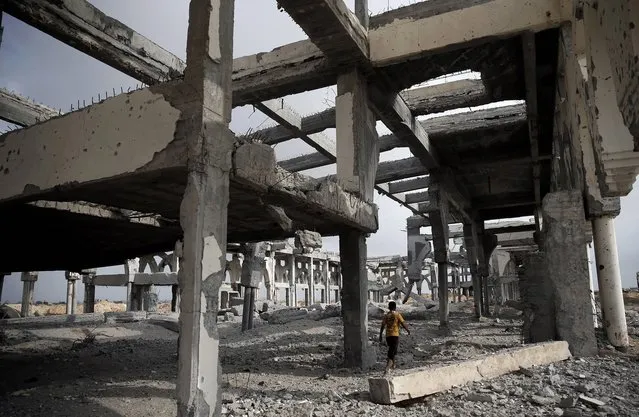 A Palestinian boy makes his way through the rubble of the destroyed and deserted terminal of the Gaza strips former international airport in the southern city of Rafah on August 18, 2014. Egyptian-brokered indirect negotiations between Israel and the Palestinians are taking place during a five-day lull in the fighting that is due to expire at midnight (21:00 GMT). (Photo by Thomas Coex/AFP Photo)