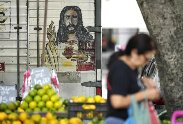 A woman walks past a fruit vendor at a street market in Rio de Janeiro, Brazil, Wednesday, May 11, 2022. High inflation in Brazil is eroding the buying power of consumers and angering potential voters, who fault President Jair Bolsonaro for not doing enough about it. (Photo by Silvia Izquierdo/AP Photo)