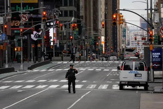 A New York City Police officer (NYPD) takes a selfie while in the middle of the street in an almost empty Times Square, during the coronavirus disease (COVID-19) outbreak, in New York City, U.S., March 31, 2020. (Photo by Brendan McDermid/Reuters)