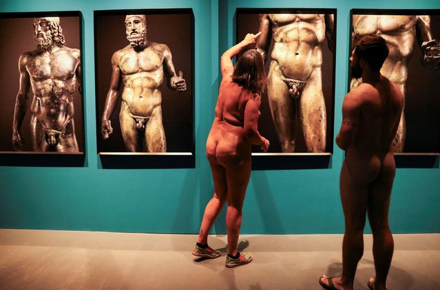 Guide Edgard Mestre talks with Marta, 59, as they take part in a nudist visit to the Archaeology Museum of Catalonia about The Bronzes of Race exhibition of Luigi Spina’s photographs depicting two large Greek bronze statues of naked in Barcelona, Spain on October 28, 2023. (Photo by Nacho Doce/Reuters)