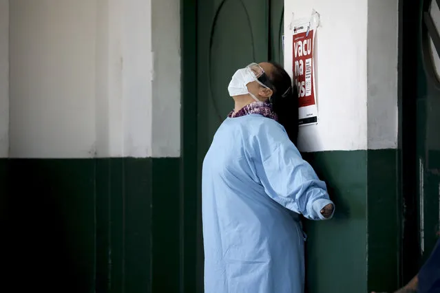 A worker at the Manuel Belgrano public hospital stretches outside the public hospital on the outskirts of Buenos Aires, Argentina, Friday, April 17, 2020. Argentina confirmed a coronavirus outbreak at this hospital where people, including hospital staff, have tested positive, according to its director Nicolás Rodríguez. (Photo by Natacha Pisarenko/AP Photo)