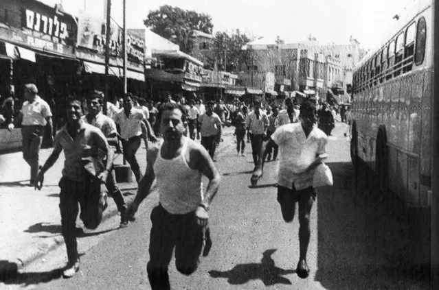 Israelis scatter in Tel Aviv, September 4, 1968 after three terrorist bombs exploded in a crowded bus station, killing one man and injuring 49 others. The bombs, hidden in litter bins, sent pieces of metal flying like shrapnel into crowds of waiting Israeli and Arab passengers. It was the worst incident of sabotage in Tel Aviv in ten years. (Photo by AP Photo)