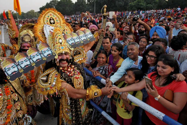An artist dressed as demon King Ravana reacts as he shakes hands with people during Vijaya Dashmi, or Dussehra festival celebrations in Chandigarh, September 30, 2017. (Photo by Ajay Verma/Reuters)