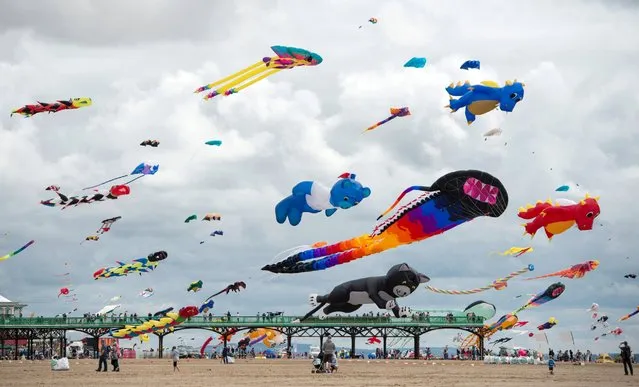 Kite enthusiasts participate in the St Annes Kite Festival on the seafront in Lytham St Annes, north west England on July 30, 2016. (Photo by Oli Scarff/AFP Photo)
