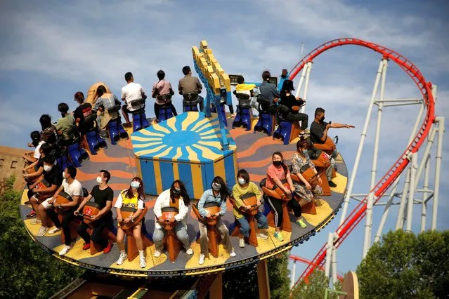 People wearing face masks enjoy the attraction while visiting the Happy Valley amusement park, following an outbreak of the coronavirus disease (COVID-19), in Beijing, China on May 10, 2020. (Photo by Carlos Garcia Rawlins/Reuters)