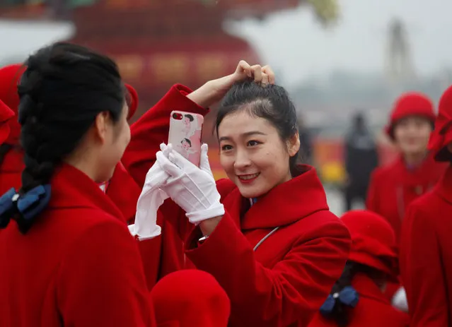 Ushers prepare themselves for photos at the Tiananmen Square during the opening of the 19th National Congress of the Communist Party of China at the Great Hall of the People in Beijing, China on October 18, 2017. (Photo by Ahmad Masood/Reuters)