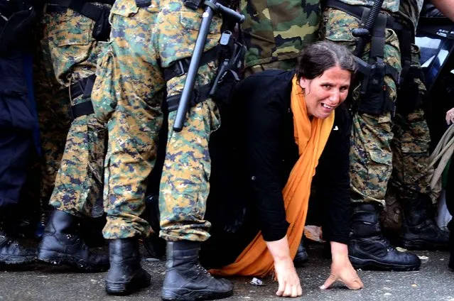 A woman cries as she crawls through the border police block in the southern Macedonian town of Gevgelija, Thursday, September 10, 2015. Hundred of thousands migrants and refugees trying to reach the heart of Europe via Turkey, Greece, the Balkans and Hungary have faced dangers, difficulties and delays on every link of the journey. (Photo by Borce Popovski/AP Photo)