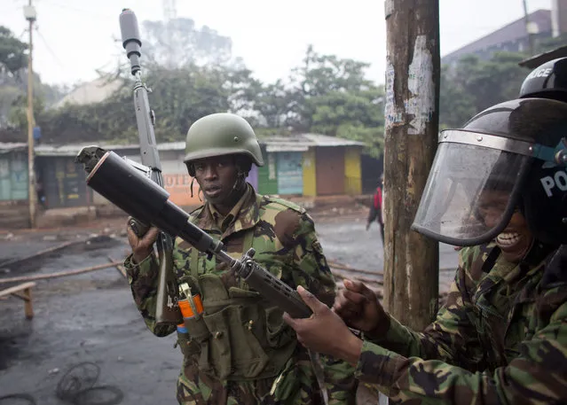 Police prepare to use teargas against protesters in the Kibera slum in Nairobi, Kenya, Thursday, October 26, 2017. Kenya is holding the rerun of its disputed presidential election Thursday, despite a boycott by the main opposition party and rising political tensions in the East African country. (Photo by Darko Bandic/AP Photo)