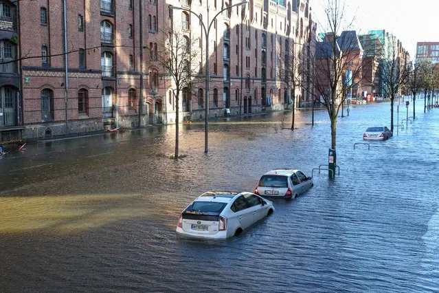 Flood waters surround cars parked at Hamburg's Fish Market district on October 29, 2017 as a storm hit many parts of Germany. At least three people died in a windstorm that hit central Europe early on on October 29, 2017, causing widespread power outages and traffic disruptions, rescuers said. (Photo by Bodo Marks/AFP Photo)