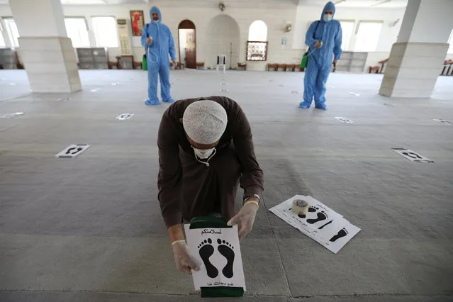 Imam of one the mosques puts foot print mats for social distancing to prevent the spread of the coronavirus disease (COVID-19) after the government announced that it will open places of worship to worshipers from tomorrow in Amman, Jordan, June 4, 2020. (Photo by Muhammad Hamed/Reuters)