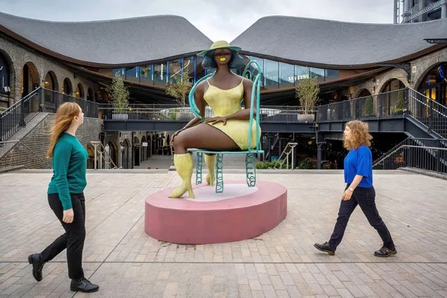 Women walk past Tschabalala Self's “Seated”, a newly unveiled public work commissioned by Avant Arte, at Coal Drops Yard near King's Cross in London on October 5, 2022. The large-scale bronze stands at nearly 3 metres tall and is the artist's first public sculpture. (Photo by Stephen Chung/Alamy Live News)