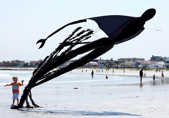 A boy plays with a kite depicting a dementor from the Harry Potter series during the 28th Cape Town International Kite Festival, an awareness-campaign for World Mental Health Day where kite enthusiasts gather to fly colourful kites, participate in social activities, and raise funds for mental health support at Melkbosstrand, Cape Town, South Africa on October 9, 2022. (Photo by Esa Alexander/Reuters)