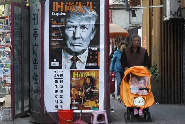 In this Wednesday, March 15, 2017, file photo, a man pushes a stroller past a magazine advertisement featuring U.S. President Donald Trump at a newsstand in Shanghai, China. President Donald Trump's agenda in Beijing is expected to be led by the standoff over North Korea's nuclear weapons and demands that China do more to balance trade with America. (Photo by Chinatopix via AP Photo)