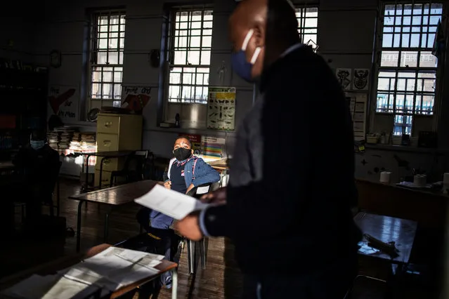 Pupils at the City Kidz Pre & Primary School in the Inner City district in Johannesburg sits in class as a teacher checks the register on June 1, 2020. South Africa moved into level three of a five-tier lockdown on June 1, 2020, to continue efforts to curb the spread of the COVID-19 coronavirus. Under level three, all but high-risk sectors of the economy will be allowed to reopen There are however a lot of confusion around the reopening of schools as some schools have opened and others remain closed. (Photo by Marco Longari/AFP Photo)