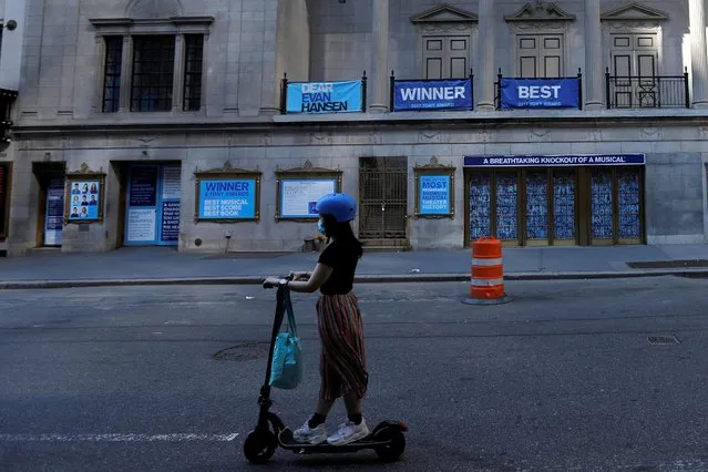 A woman rides a scooter past the shuttered Music Box Theatre, home of the popular musical “Dear Evan Hansen” after industry group the Broadway League said Broadway theaters will remain closed through January 3, 2021, in New York, July 2, 2020. (Photo by Mike Segar/Reuters)