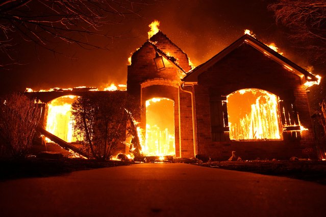 Fire burns a residence during a wildfire outbreak in Stillwater, Oklahoma, on March 14, 2025. (Photo by Nick Oxford/Reuters)