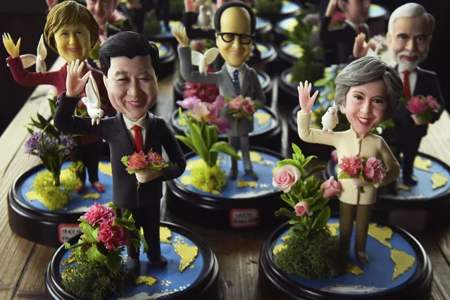 In this Sunday, August 28, 2016 photo, clay figures front role from right featuring Britain's Prime Minister Theresa May next to Chinese President Xi Jinping, and other G20 leaders made by a female artist Wu Xiaoli on display at a shop to mark the upcoming G20 Summit held in Hangzhou in east China's Zhejiang province. On her first visit to China as Britain's prime minister, Theresa May will try to reassure Beijing that she wants to strengthen ties despite her delay on a decision over whether to approve a Chinese-backed nuclear power plant in southwestern England. (Photo by Chinatopix via AP Photo)