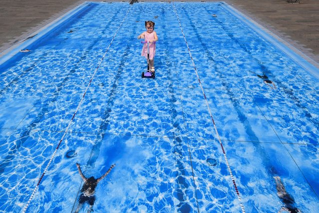 Eliza, 3, scoots over a piece of temporary floor art depicting a swimming pool, amid the coronavirus disease (COVID-19) outbreak, in London, Britain on August 12, 2020. (Photo by Toby Melville/Reuters)