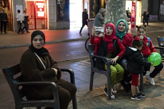 Morocco fans sit on street benches during celebrations in Barcelona, Spain, Tuesday, December 6, 2022. Morocco beat Spain on penalties in a round of 16 World Cup soccer tournament in Qatar. (Photo by Pau de la Calle/AP Photo)