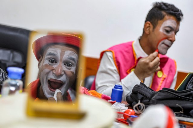 A member of the Gaza Circus School relief team applies his clown makeup before performing for children at the Abdelaziz al-Rantisi Paediatric Hospital in Gaza City on April 15, 2025.  (Photo by Omar Al-Qattaa/AFP Photo)