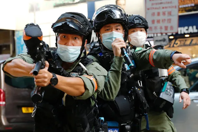 A riot police uses pepper spray gun to disperse pro-democracy protesters during a demonstration opposing postponed elections, in Hong Kong, China on September 6, 2020. (Photo by Tyrone Siu/Reuters)