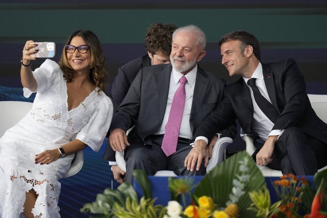 Brazilian first lady Rosangela da Silva takes a selfie with France's President Emmanuel Macron, right, and her husband Brazilian President Luiz Inacio Lula da Silva during the launch ceremony of the Tonelero submarine, made in Brazil with French technology, in Itaguai, Rio de Janeiro state, Brazil, Wednesday, March 27, 2024. Macron is on a three-day visit to Brazil. (Photo by Silvia Izquierdo/AP Photo)