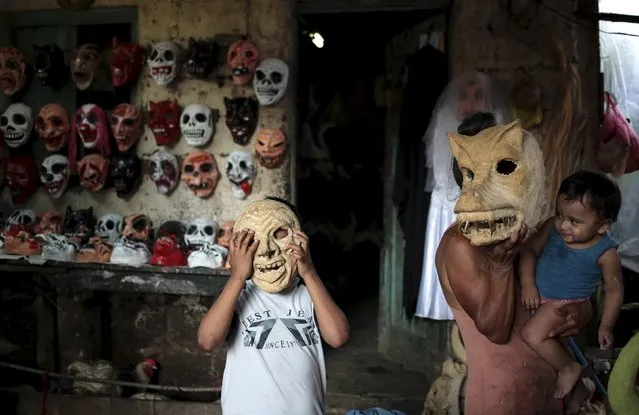 A child tries on masks before the Los Aguizotes festival in the indigenous community of Monimbo in Masaya, Nicaragua, October 16, 2015. (Photo by Oswaldo Rivas/Reuters)