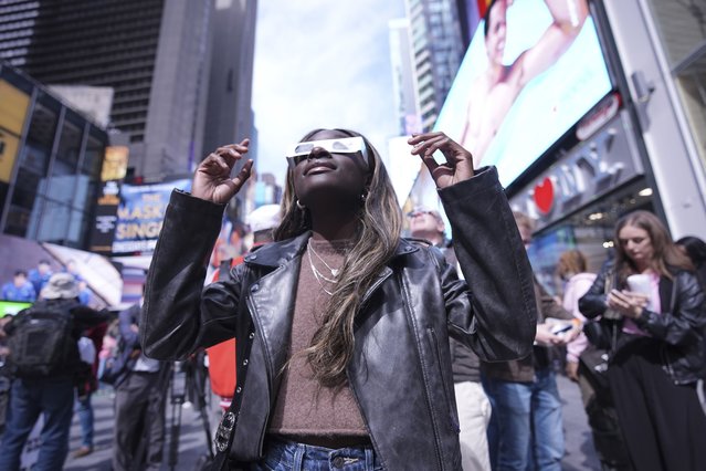 A woman views the solar eclipse in Times Square, Monday, April 8, 2024, in New York. (Photo by Peter K. Afriyie/AP Photo)