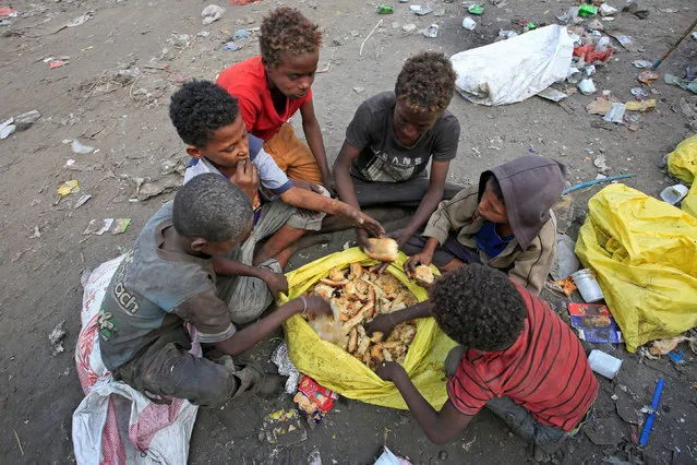 Boys eat bread they collected from a garbage dump on the outskirts of the Red Sea port city of Hodeida, Yemen January 7, 2018. (Photo by Abduljabbar Zeyad/Reuters)