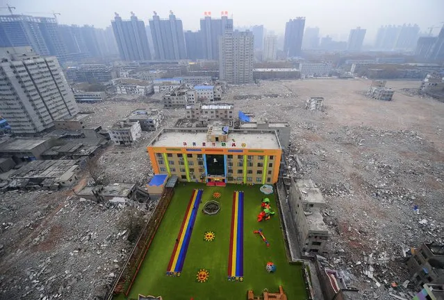 A kindergarten is seen surrounded by rubble at a demolition site in Xi'An, Shaanxi province, December 8, 2014. According to local government, the kindergarten has been running without license and will be forced to shut down. (Photo by Reuters/Stringer)