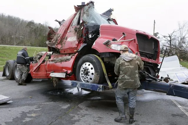Two men work to remove a truck in Botkinburg, Ark., Thursday, April 11, 2013, that was overturned when a severe storm struck the area late Wednesday. The National Weather Service is surveying areas Thursday to determine whether tornadoes or strong winds caused damage. (Photo by AP Photo/Danny Johnston)