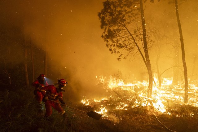 Members of the Emergency Military Unit (UME) work to extinguish a wildfire next to a village on August 19, 2025 in Pepín, in Ourense province, Spain. The autonomous community of Galicia has been experiencing a prolonged heatwave for 16 days this summer, and daily temperatures have reached 45 °C.  The heat and dried-out land have fueled wildfires across the region that have destroyed 115,000 hectares so far, closing Spain's world-famous pilgrims' route, the Camino de Santiago, that leads to the Galician town of  Santiago de Compostela. The Spanish army has deployed nearly 2000 troops to help firefighters, and four people have died in Spain's worst wildfires on record. (Photo by Pablo Blazquez Dominguez/Getty Images)