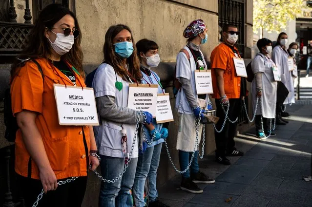 Representatives of hospital services chain themselves around the health department to protest demanding better working conditions and against the mistreatment of their sector during the COVID-19 pandemic in Madrid, Spain, on November 23, 2020. (Photo by Marcos del Mazo/LightRocket via Getty Images)