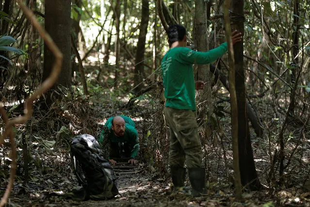 Researcher Diogo Maia Grabin (L) and his assistant Railgler dos Santos from the Mamiraua Institute install camera traps at the Mamiraua Sustainable Development Reserve in Uarini, Amazonas state, Brazil, February 9, 2018. (Photo by Bruno Kelly/Reuters)
