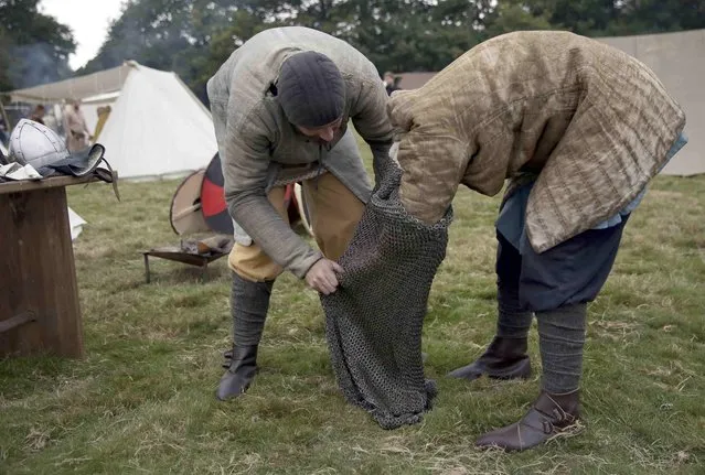 Re-enactors dress before a re-enactment of the Battle of Hastings, commemorating the 950th anniversary of the battle, in Battle, Britain October 15, 2016. (Photo by Neil Hall/Reuters)