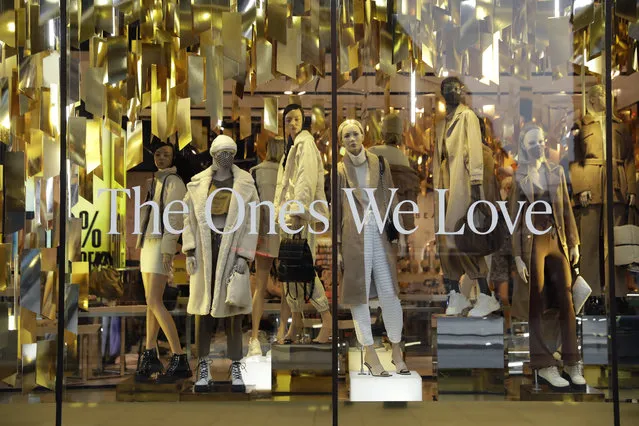 Mannequins, some wearing face masks, display clothes in the front window of the temporarily closed Topshop flagship store on Oxford Street, during England's second coronavirus lockdown, in London, Monday, November 30, 2020. Arcadia Group, the retail empire of tycoon Philip Green, which owns well-known British fashion chains like Topshop and employs around 15,000 people, appears to be on the brink of collapse following the economic shock of the coronavirus pandemic. (Photo by Matt Dunham/AP Photo)