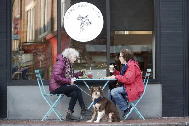 Lenora Kahn, her dog Bella, and Judith Albert dine outside of Marjoram Roux on Railroad Street in Great Barrington, Mass., Friday, December 11, 2020. Even as the weather gets chilly, outdoor dining is safer than dining indoors at a restaurant. (Photo by Ben Garver/The Berkshire Eagle via AP Photo)